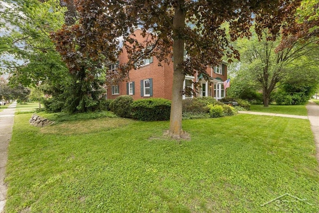 2505 Court St, Saginaw, MI 48602 - view of home's exterior featuring a yard and brick siding
