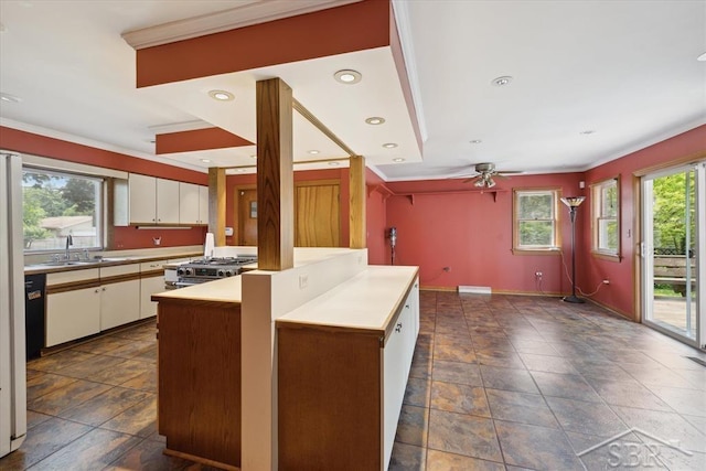 2505 Court St, Saginaw, MI 48602 - kitchen with crown molding, light countertops, white cabinets, dark stone finish flooring, and stainless steel stove