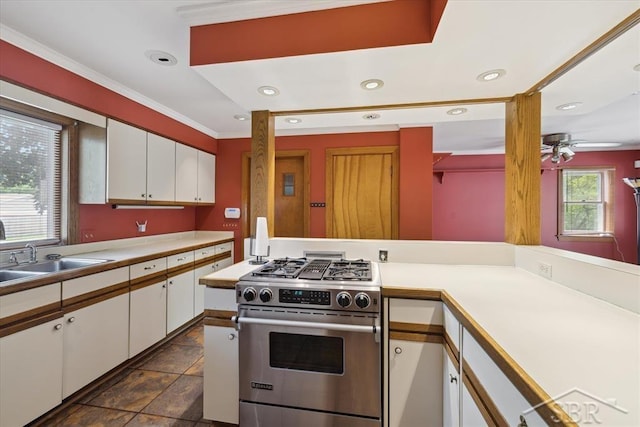 2505 Court St, Saginaw, MI 48602 - kitchen featuring gas range, white cabinets, light countertops, a sink, and ornamental molding