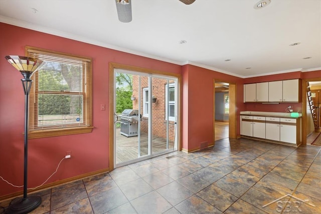 2505 Court St, Saginaw, MI 48602 - kitchen with baseboards, ceiling fan, crown molding, and white cabinets