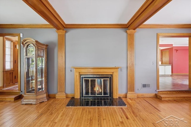 2505 Court St, Saginaw, MI 48602 - unfurnished living room featuring decorative columns, crown molding, hardwood / wood-style floors, baseboards, and beamed ceiling