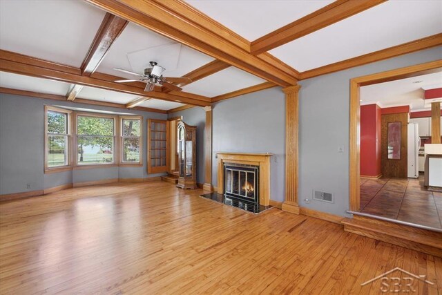 2505 Court St, Saginaw, MI 48602 - unfurnished living room featuring ceiling fan, baseboards, hardwood / wood-style floors, a high end fireplace, and beamed ceiling