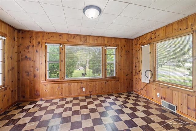 2505 Court St, Saginaw, MI 48602 - empty room featuring healthy amount of natural light, wooden walls, tile patterned floors, and baseboards