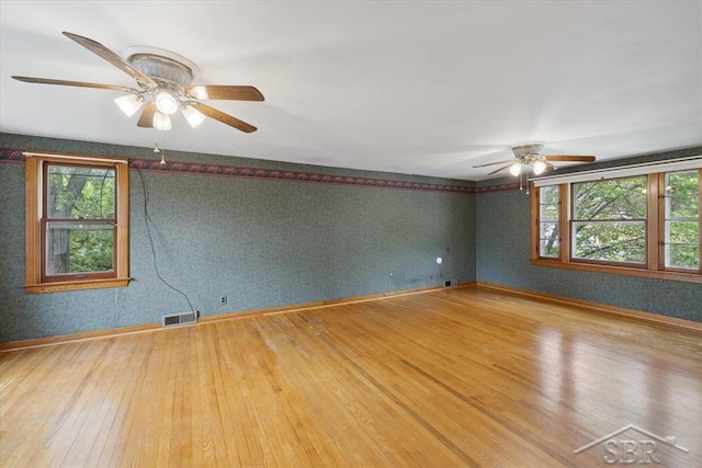 2505 Court St, Saginaw, MI 48602 - spare room with a ceiling fan, wallpapered walls, hardwood / wood-style flooring, and healthy amount of natural light