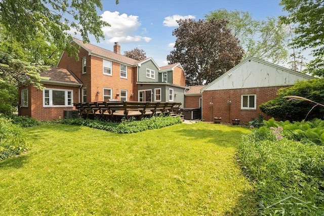 2505 Court St, Saginaw, MI 48602 - back of house featuring brick siding, a yard, a deck, a chimney, and central AC unit