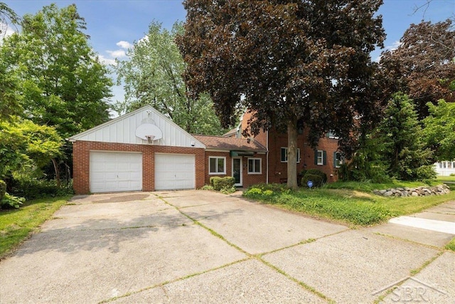 2505 Court St, Saginaw, MI 48602 - view of front of property featuring an attached garage, brick siding, board and batten siding, and driveway