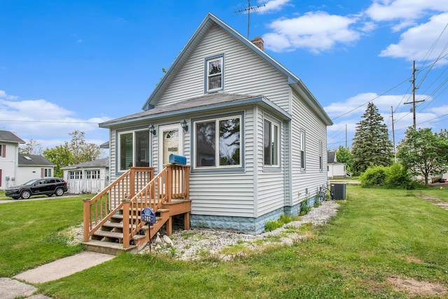 202 Maple St, Three Oaks, MI 49128 - view of front of house with central AC, a chimney, and a front yard