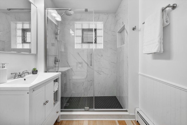 12270 Linden Ave, Sawyer, MI 49125 - full bathroom featuring a marble finish shower, vanity, wood finished floors, a baseboard radiator, and wainscoting