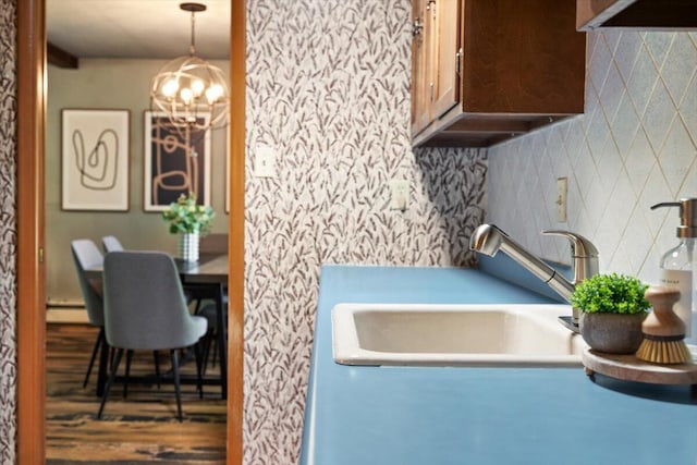 12270 Linden Ave, Sawyer, MI 49125 - kitchen featuring backsplash, a baseboard radiator, wood finished floors, a sink, and a chandelier