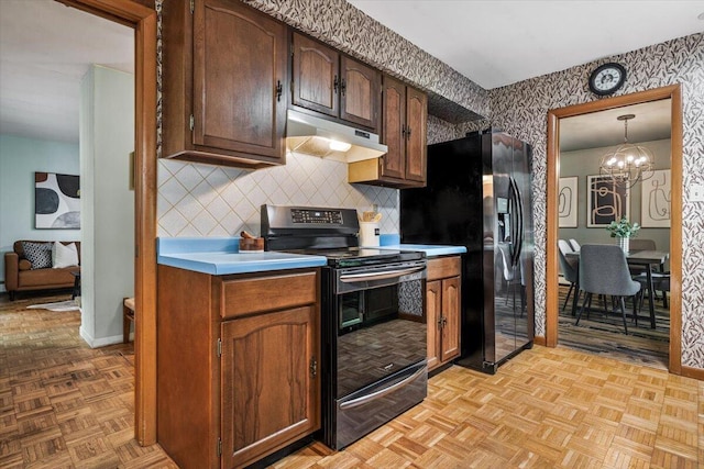 12270 Linden Ave, Sawyer, MI 49125 - kitchen featuring stainless steel appliances, under cabinet range hood, wallpapered walls, a chandelier, and baseboards