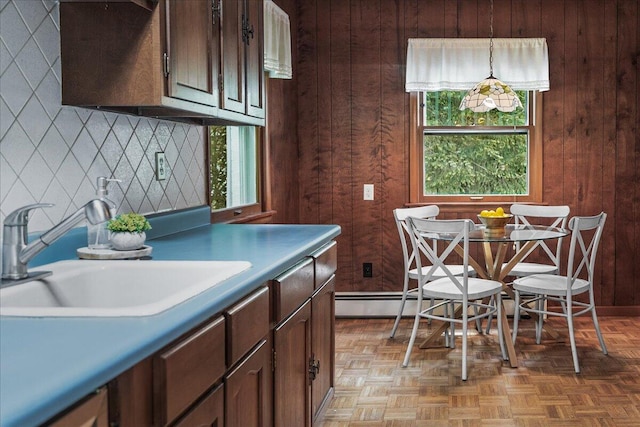 12270 Linden Ave, Sawyer, MI 49125 - kitchen with a sink, wooden walls, decorative backsplash, hanging light fixtures, and baseboard heating