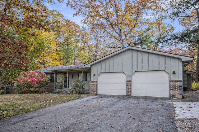 7362 30th St SE, Ada, MI 49301 - ranch-style home with brick siding, board and batten siding, a garage, and driveway