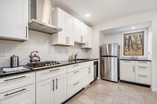 7362 30th St SE, Ada, MI 49301 - kitchen featuring appliances with stainless steel finishes, wall chimney exhaust hood, a sink, backsplash, and white cabinets