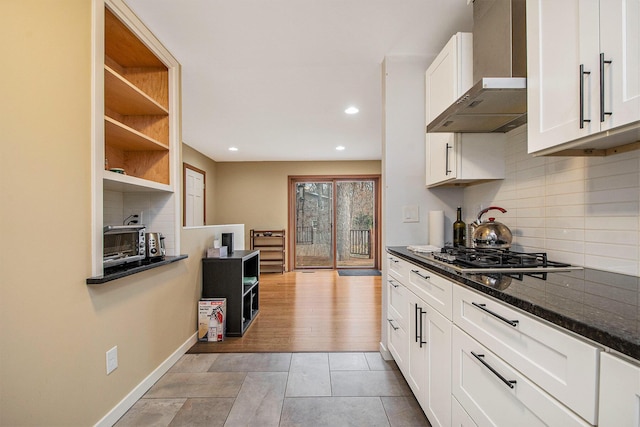 7362 30th St SE, Ada, MI 49301 - kitchen featuring wall chimney range hood, stainless steel gas stovetop, open shelves, decorative backsplash, and white cabinetry