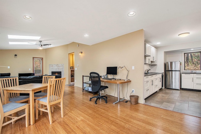 7362 30th St SE, Ada, MI 49301 - office area with a skylight, a warm lit fireplace, a sink, recessed lighting, and baseboards
