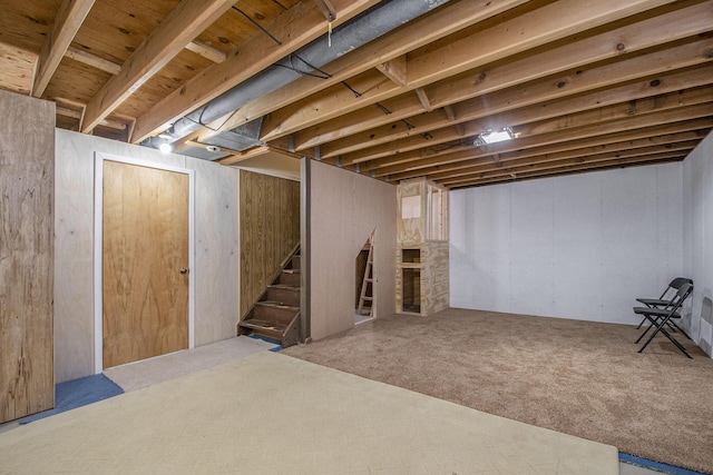 7362 30th St SE, Ada, MI 49301 - below grade area featuring carpet flooring, stairway, and a fireplace