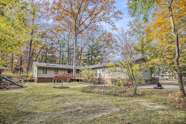 7362 30th St SE, Ada, MI 49301 - rear view of house featuring a lawn, a wooden deck, and a playground