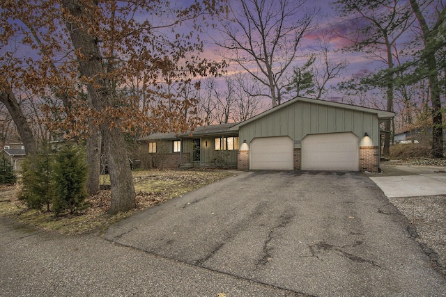 7362 30th St SE, Ada, MI 49301 - view of front of property featuring brick siding, a garage, and driveway