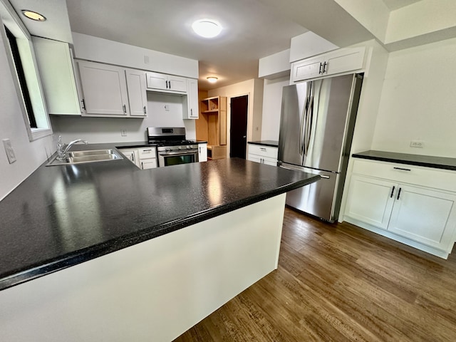 7362 30th St SE, Ada, MI 49301 - kitchen with appliances with stainless steel finishes, a sink, a peninsula, dark wood-style flooring, and dark countertops