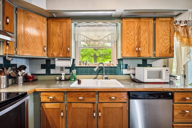 50902 Magician Lk Rd, Dowagiac, MI 49047 - kitchen featuring dishwasher, a sink, white microwave, tasteful backsplash, and brown cabinetry