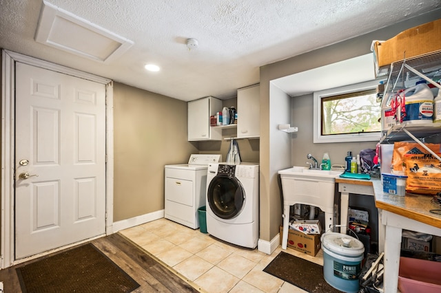 50902 Magician Lk Rd, Dowagiac, MI 49047 - laundry area featuring attic access, cabinet space, washer and clothes dryer, baseboards, and a textured ceiling