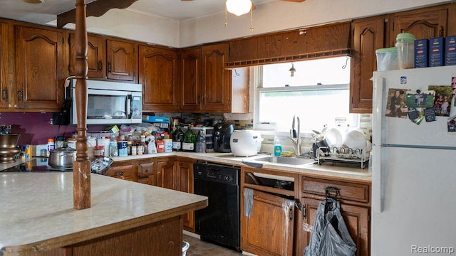 4107 Windward Dr, Lansing, MI 48911 - kitchen with freestanding refrigerator, stainless steel microwave, black dishwasher, a sink, and light countertops