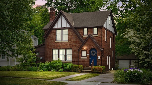 1512 Shadford Rd, Ann Arbor, MI 48104 - english style home with a chimney, roof with shingles, brick siding, a front yard, and board and batten siding