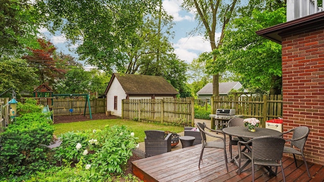 1512 Shadford Rd, Ann Arbor, MI 48104 - wooden deck featuring outdoor dining space, a fenced backyard, a grill, and a playground