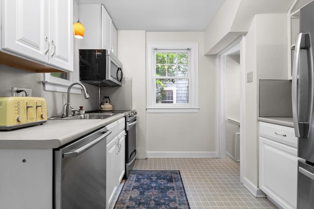 1512 Shadford Rd, Ann Arbor, MI 48104 - kitchen with appliances with stainless steel finishes, white cabinetry, a sink, light countertops, and baseboards