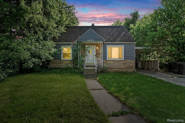 1621 Greenbrook Ln, Flint, MI 48507 - bungalow-style house with stone siding, a front yard, roof with shingles, and driveway