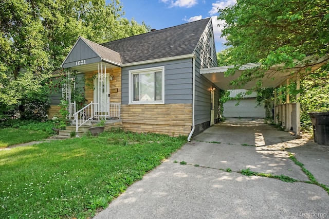 1621 Greenbrook Ln, Flint, MI 48507 - view of front of house with stone siding, driveway, roof with shingles, a front lawn, and a carport