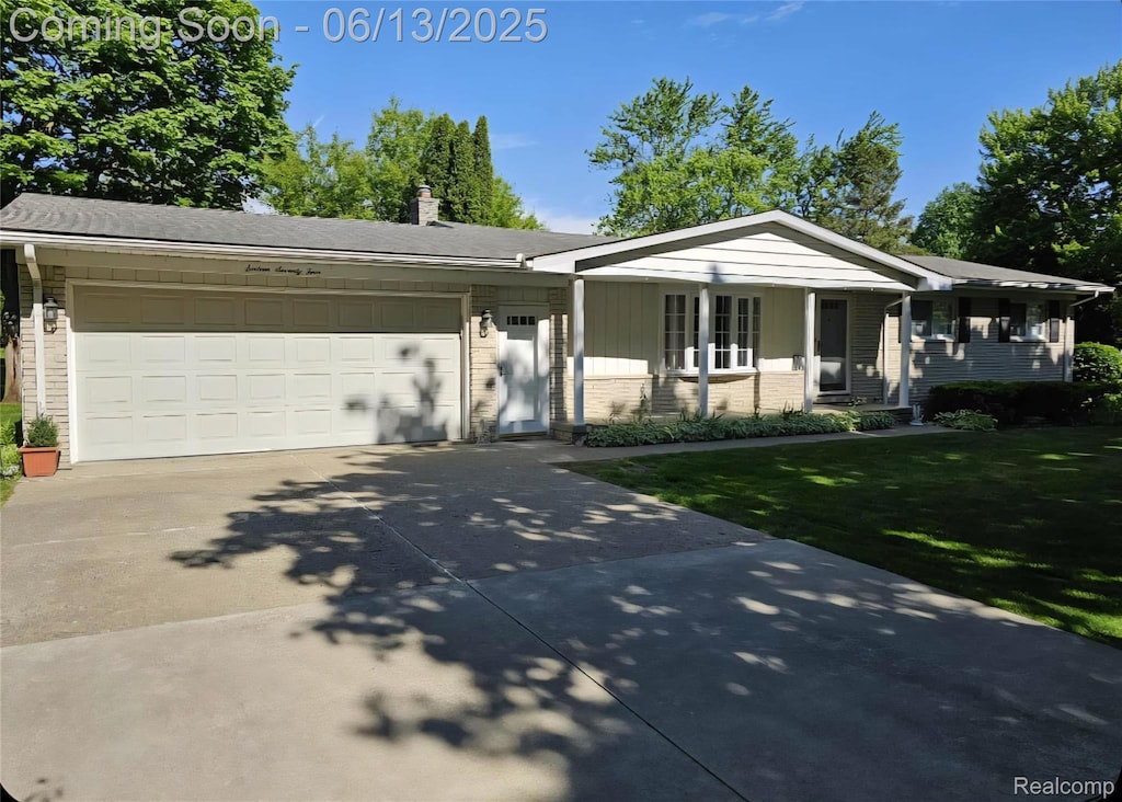 1674 Newark Ave, Pontiac, MI 48340 - ranch-style house with concrete driveway, a front yard, brick siding, and an attached garage