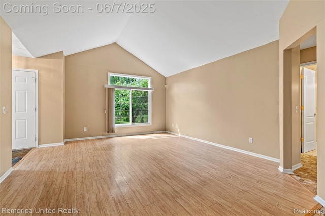 2663 Maple Forest Dr, Wixom, MI 48393 - unfurnished living room with light wood-type flooring, vaulted ceiling, and baseboards