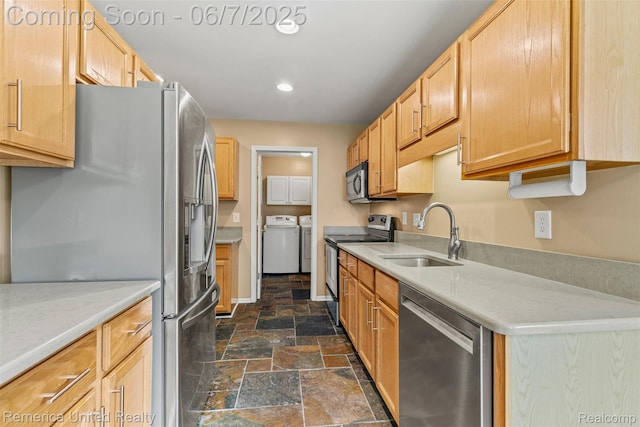 2663 Maple Forest Dr, Wixom, MI 48393 - kitchen featuring stainless steel appliances, a sink, washer and clothes dryer, stone tile floors, and recessed lighting