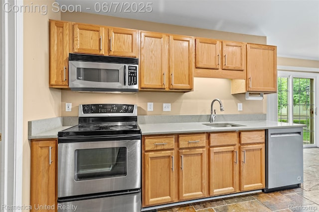 2663 Maple Forest Dr, Wixom, MI 48393 - kitchen featuring stainless steel appliances, a sink, light countertops, and stone finish flooring