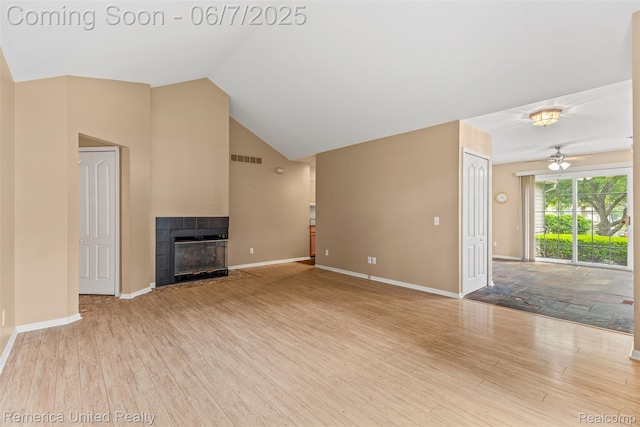 2663 Maple Forest Dr, Wixom, MI 48393 - unfurnished living room with a tiled fireplace, wood finished floors, baseboards, a ceiling fan, and lofted ceiling
