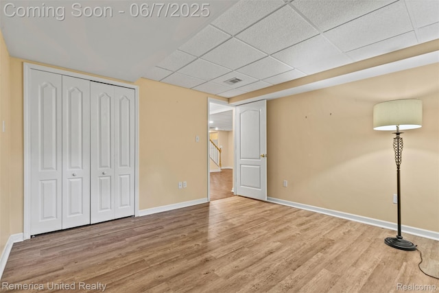 2663 Maple Forest Dr, Wixom, MI 48393 - unfurnished bedroom with a drop ceiling, wood finished floors, baseboards, and a closet