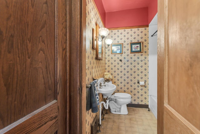 810 N Superior St, Albion, MI 49224 - full bathroom featuring wallpapered walls, toilet, tile patterned floors, a tub to relax in, and baseboards