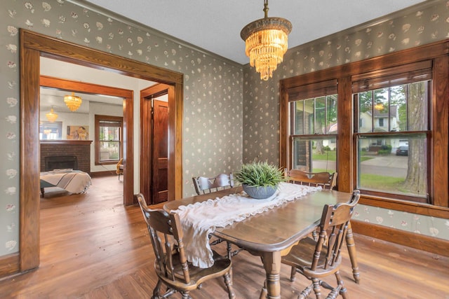 810 N Superior St, Albion, MI 49224 - dining space with wallpapered walls, wood finished floors, healthy amount of natural light, a chandelier, and crown molding