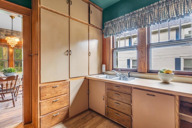 810 N Superior St, Albion, MI 49224 - kitchen with a sink, light countertops, wood finished floors, a chandelier, and decorative light fixtures