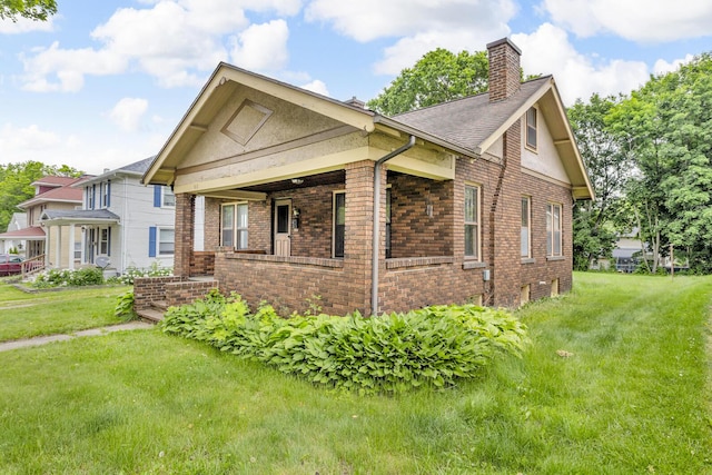 810 N Superior St, Albion, MI 49224 - view of home's exterior featuring brick siding, a chimney, a yard, and covered porch