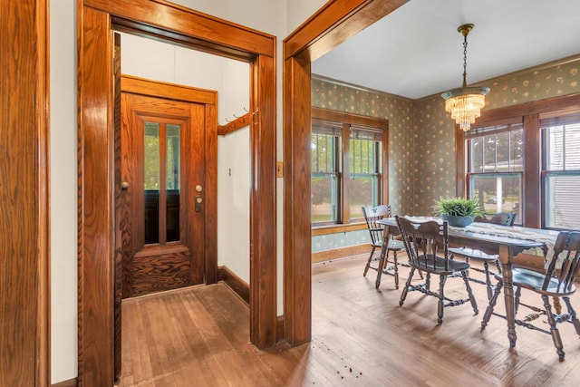 810 N Superior St, Albion, MI 49224 - dining area featuring wallpapered walls, a chandelier, hardwood / wood-style floors, and baseboards