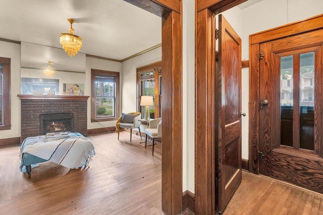 810 N Superior St, Albion, MI 49224 - bedroom with hardwood / wood-style flooring, baseboards, a brick fireplace, and a chandelier