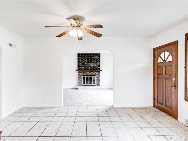 641 Michigan Ave, Marysville, MI 48040 - foyer featuring arched walkways, ceiling fan, a brick fireplace, and light carpet