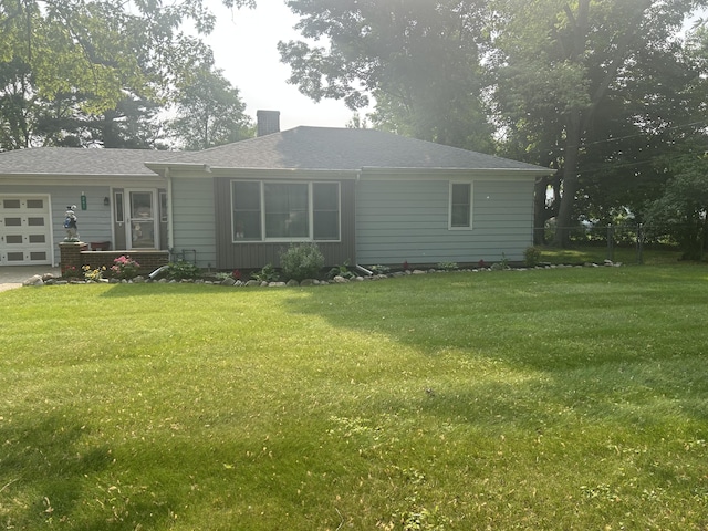 201 Goodell Ave, Colon, MI 49040 - back of property featuring a garage, a chimney, and a yard