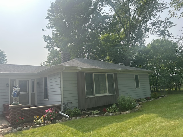 201 Goodell Ave, Colon, MI 49040 - view of property exterior featuring a lawn, a chimney, and a shingled roof