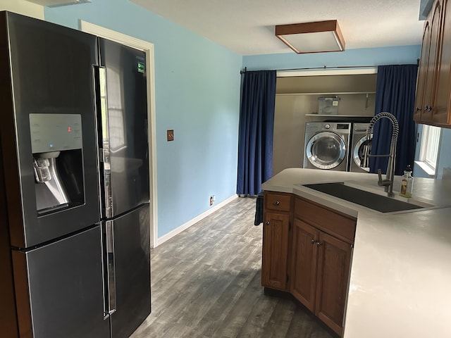 201 Goodell Ave, Colon, MI 49040 - kitchen featuring stainless steel fridge with ice dispenser, washer and clothes dryer, dark wood-type flooring, and light countertops