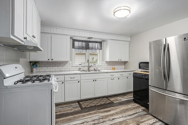1012 E Hatch St, Sturgis, MI 49091 - kitchen featuring freestanding refrigerator, white gas range, dark wood-style flooring, a sink, and light countertops