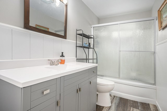 1012 E Hatch St, Sturgis, MI 49091 - full bath featuring toilet, wood finished floors, vanity, and shower / bath combination with glass door