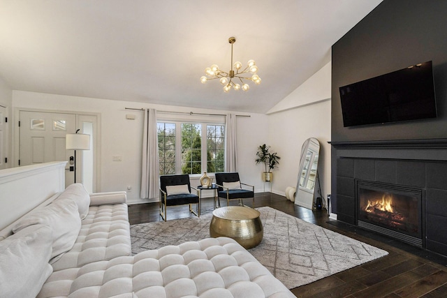 1200 Schuring Rd, Portage, MI 49024 - living room featuring a chandelier, wood finished floors, lofted ceiling, a tiled fireplace, and baseboards